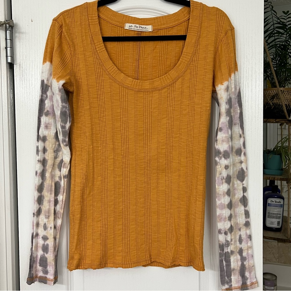 Gold shirt with tie dye sleeve accents.